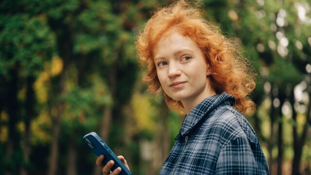 Woman in forest with phone - small